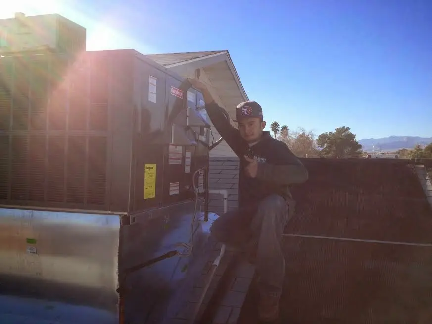 HVAC technician performing HVAC Inspection on a rooftop unit in Media